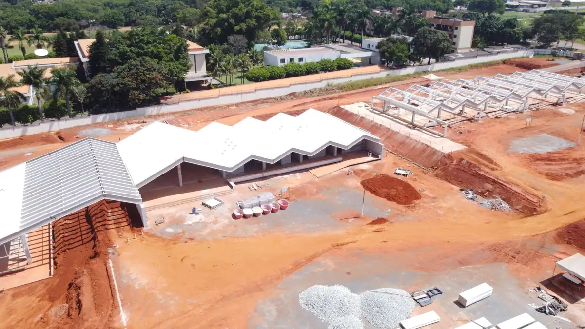 Vista aérea das coberturas metálicas já instaladas, com a estrutura ainda aparente no trecho em execução